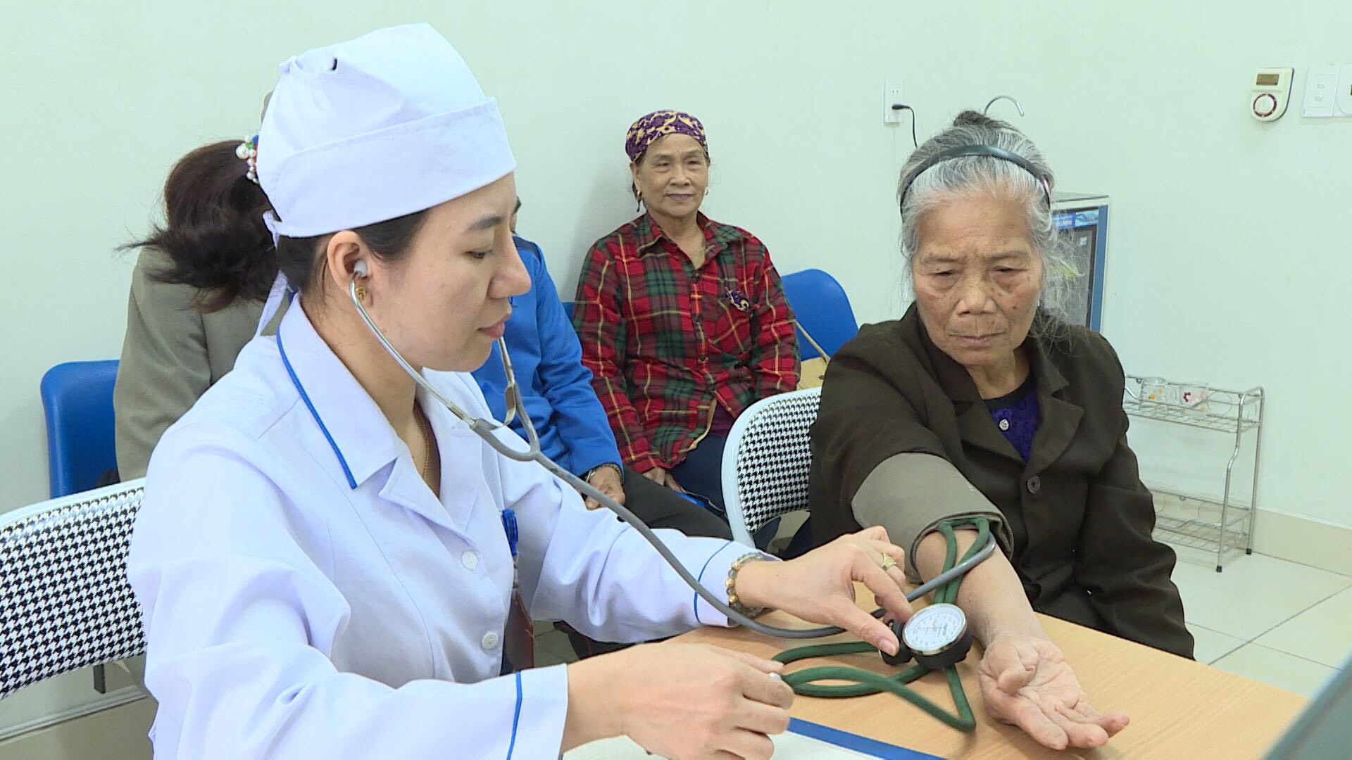 Nhân viên Trạm Y tế phường Hồng Phong, TX Đông Triều đo huyết áp cho người bệnh-