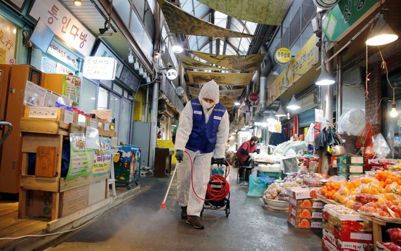 Nhân viên y tế phun thuốc khử trùng tại một khu chợ ở Hàn Quốc. Ảnh: Reuters