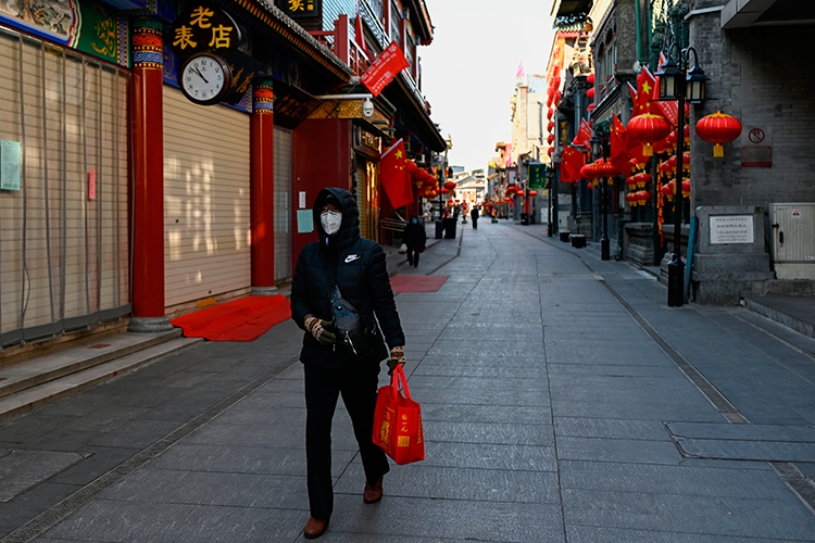 Một phụ nữ đi qua các cửa hàng đóng cửa ở thủ đô Bắc Kinh, Trung Quốc hôm 4/2. Ảnh: AFP