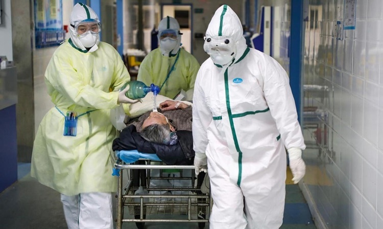 Nhân viên y tế chăm sóc bệnh nhân tại khu cách ly thuộc một bệnh viện ở Vũ Hán. Ảnh: Reuters.