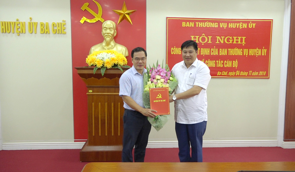 Đồng chí Đỗ Khánh Tùng - Phó Bí thư Thường trực Huyện ủy trao Quyết định và tặng hoa chúc mừng đồng chí Phạm Văn Chức.