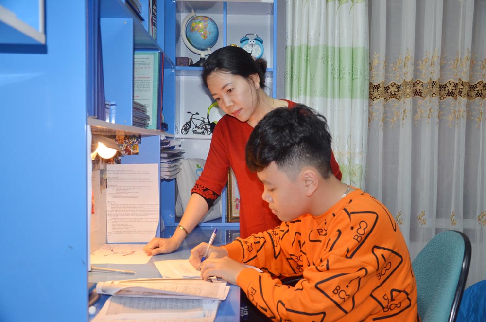 Chị Trần Thị Thanh Hải hướng dẫn con trai là em Hà Đồng Hiếu, học sinh lớp 6A5, Trường THCS Trọng Điểm, TP Hạ Long làm bài tập ở nhà.