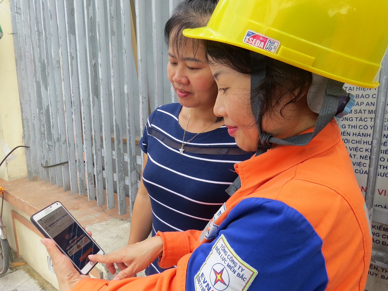 Công  nhân Điện lực TP Hạ Long hướng dẫn người dân