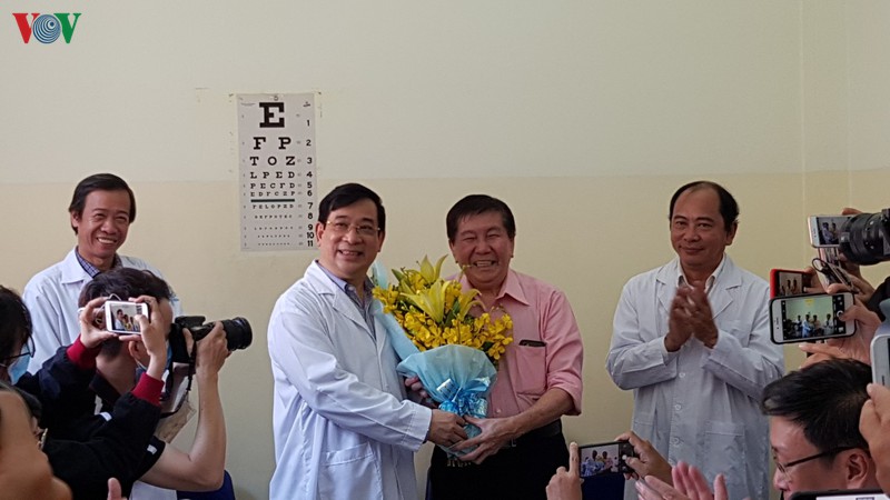 Việt kiều Mỹ 73 tuổi tặng hoa cho Đại diện Bộ Y tế. Ảnh: VOV