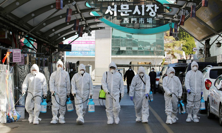 Nhân viên y tế tẩy trùng tại một khu chợ ở thành phố Daegu, phía đông nam Hàn Quốc hôm 23/2. Ảnh: AFP.