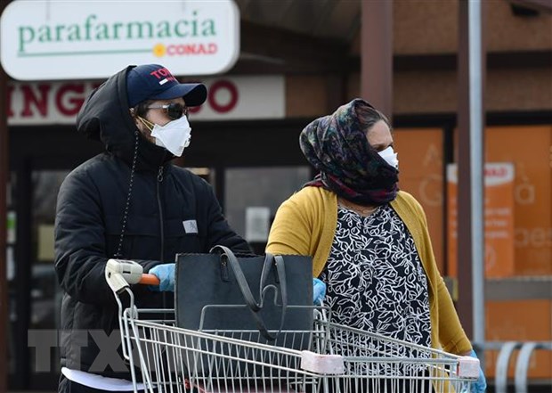 Người dân đeo khẩu trang phòng dịch viêm đường hô hấp cấp COVID-19 tại thị trấn Casalpusterlengo, Italy ngày 23/2/2020. (Ảnh: AFP/TTXVN)