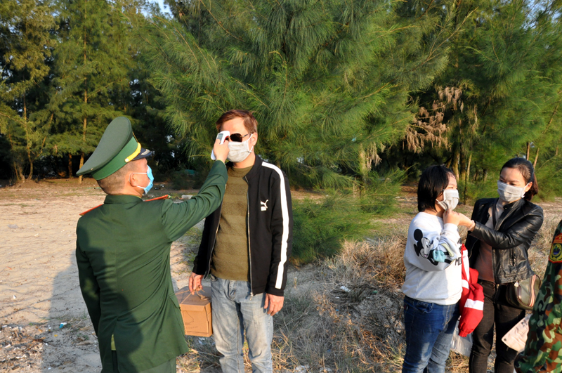 Cán bộ Quân y Đồn Biên phòng Trà Cổ kiểm tra thân nhiệt cho người dân ra, vào khu vực biên giới biển trên địa bàn Trà Cổ (TP Móng Cái)