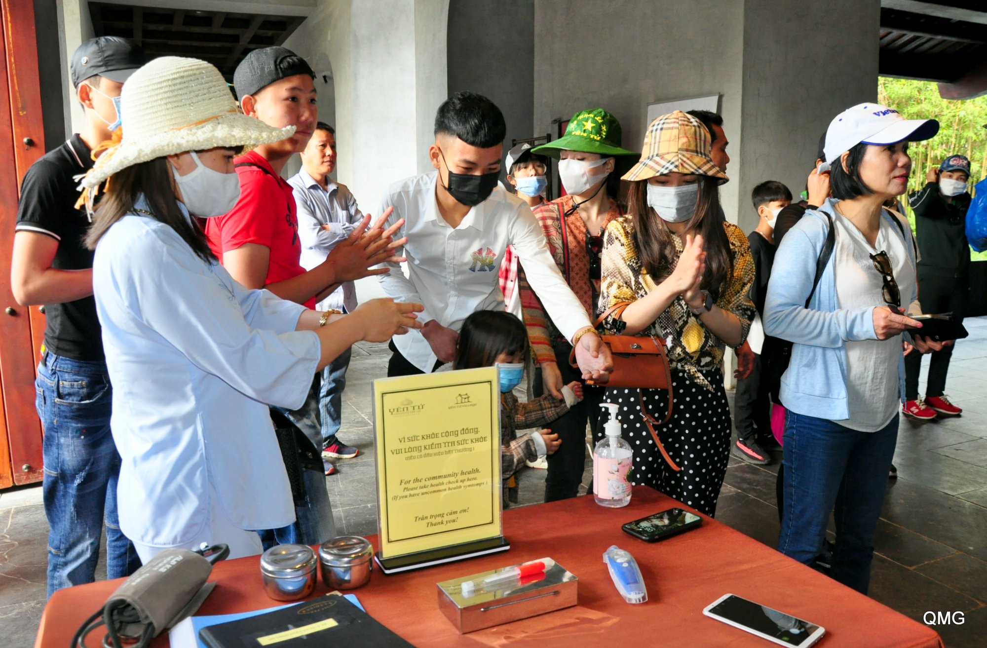 Du khách đến Yên Tử sử dụng dung dịch sát khuẩn tay miễn phí trước khi vào Khu di tích.