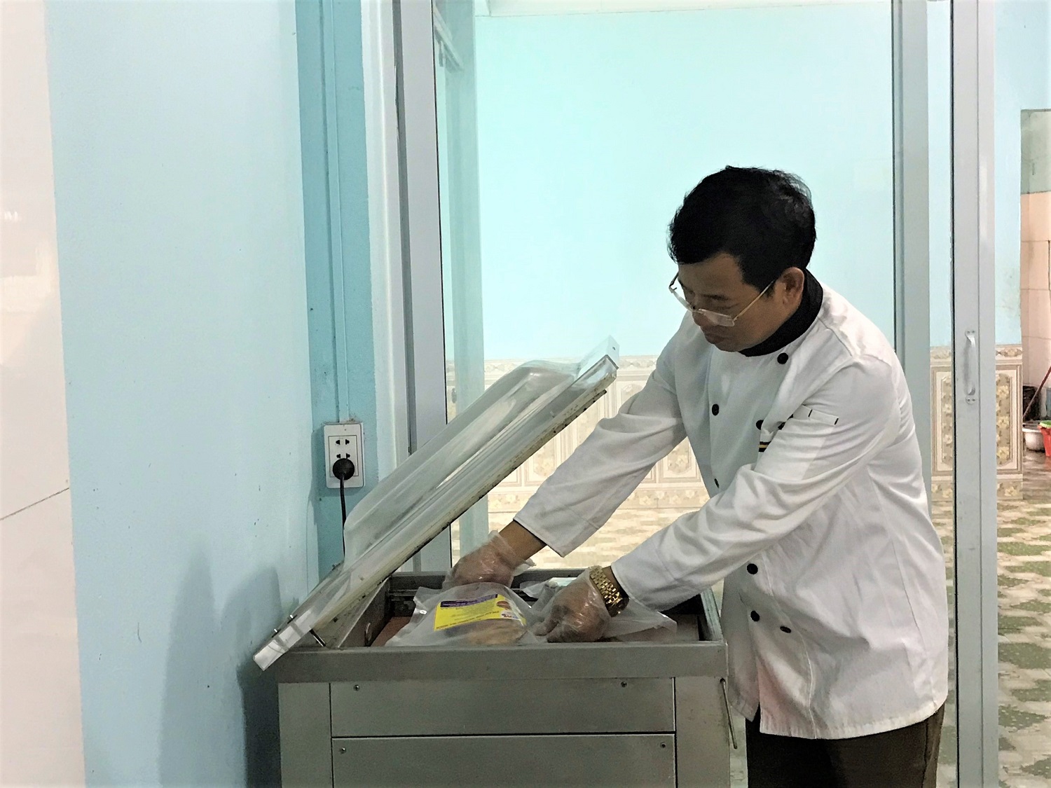 Gia đình ông Phan Văn Khôi (thôn tân mai, xã Tân Lập, huyện Đầm Hà) đầu tư gần 500 triệu đồng để phát triển khu sản xuất, chế biến chân giò nướng. Trong ảnh: Ông Khôi sử dụng máy hút chân không để bảo quản thực phẩm trước khi tiêu thụ. 