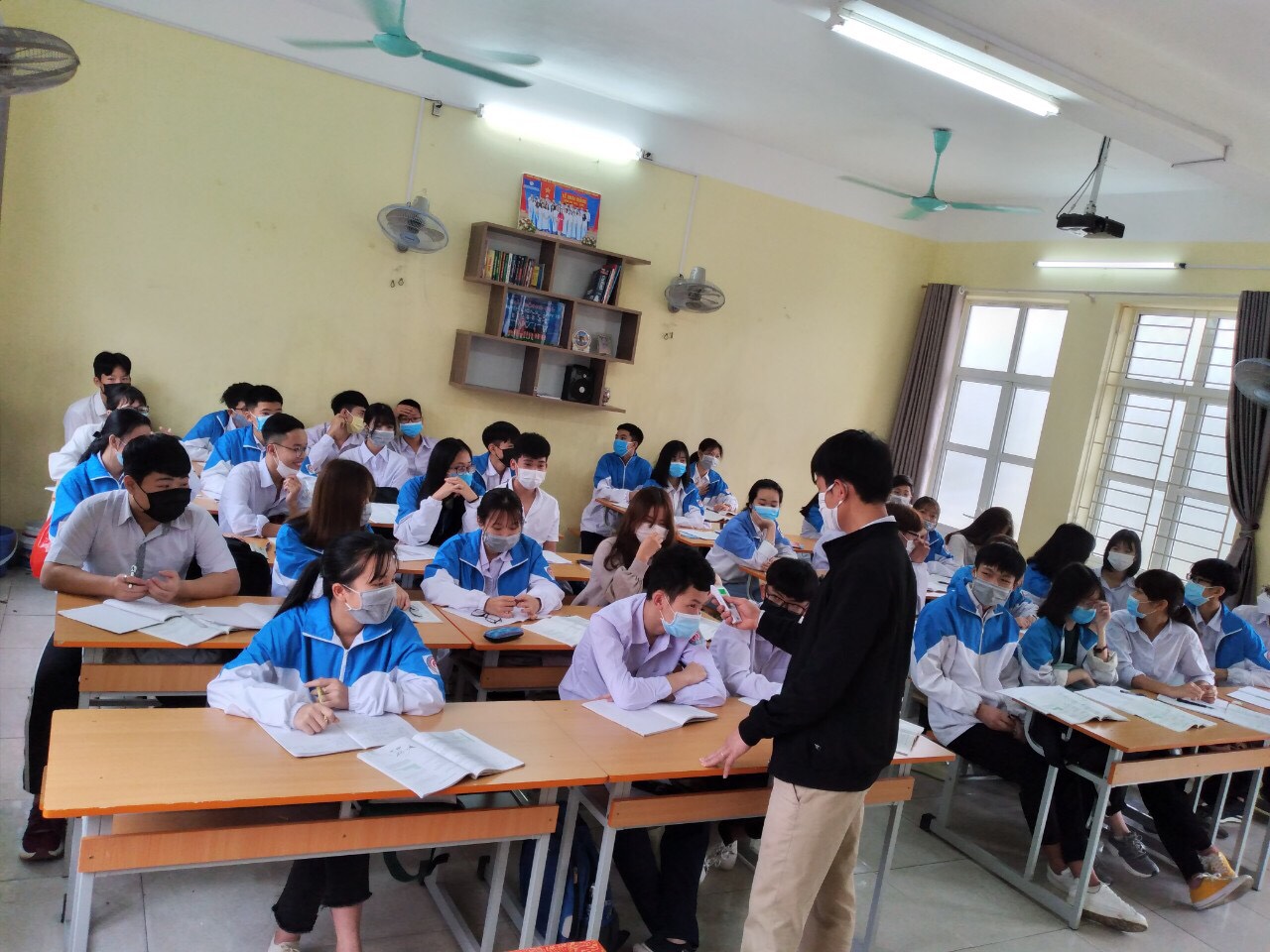 Gi áo viên Trường TH-THCS-THPT Nguyễn Bỉnh Khiêm đo thân nhiệt cho học viên. Ảnh Trung tâm cung cấp.