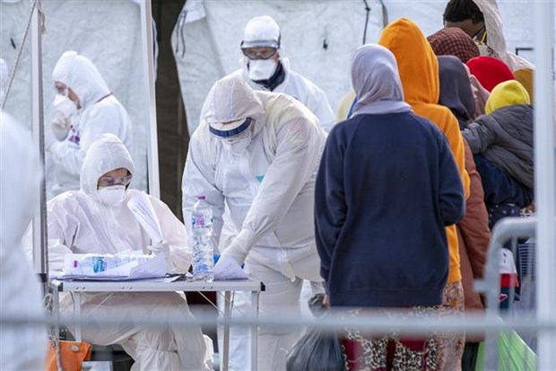 Nhân viên Hội Chữ thập đỏ Italy trong trang phục bảo hộ kiểm tra sức khỏe người di cư nhằm ngăn chặn sự lây lan của dịch COVID-19 tại khu vực cảng Messina, thành phố Sicily. (Ảnh: AFP/TTXVN)