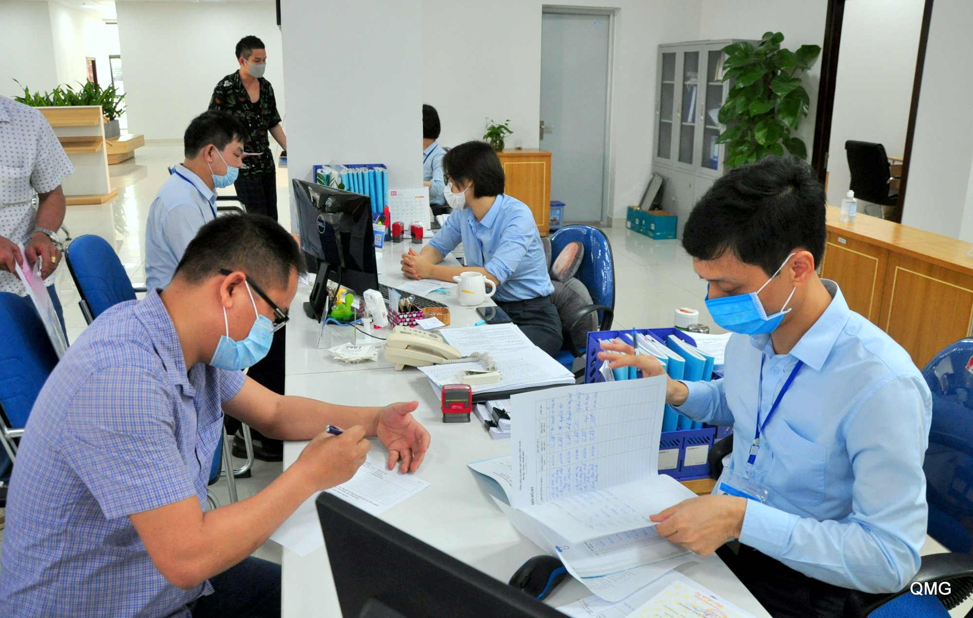 Staffs at Quang Ninh Public Service Administration Center and locals dealing withadministrative procedures at the center wore face masks