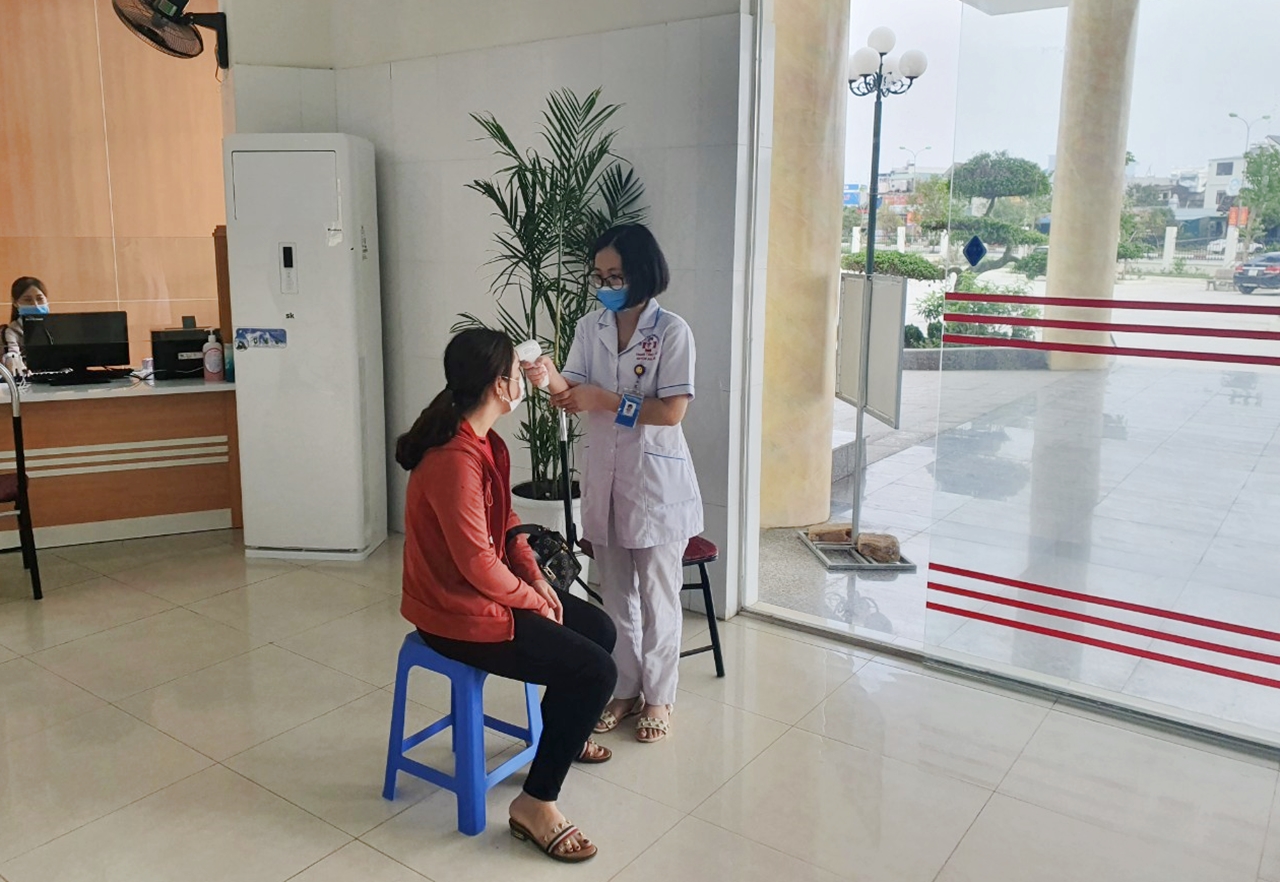 Người dân đến khám chữa bệnh tại TTYT huyện Hải Hà đều được kiểm tra đo thân nhiệt.