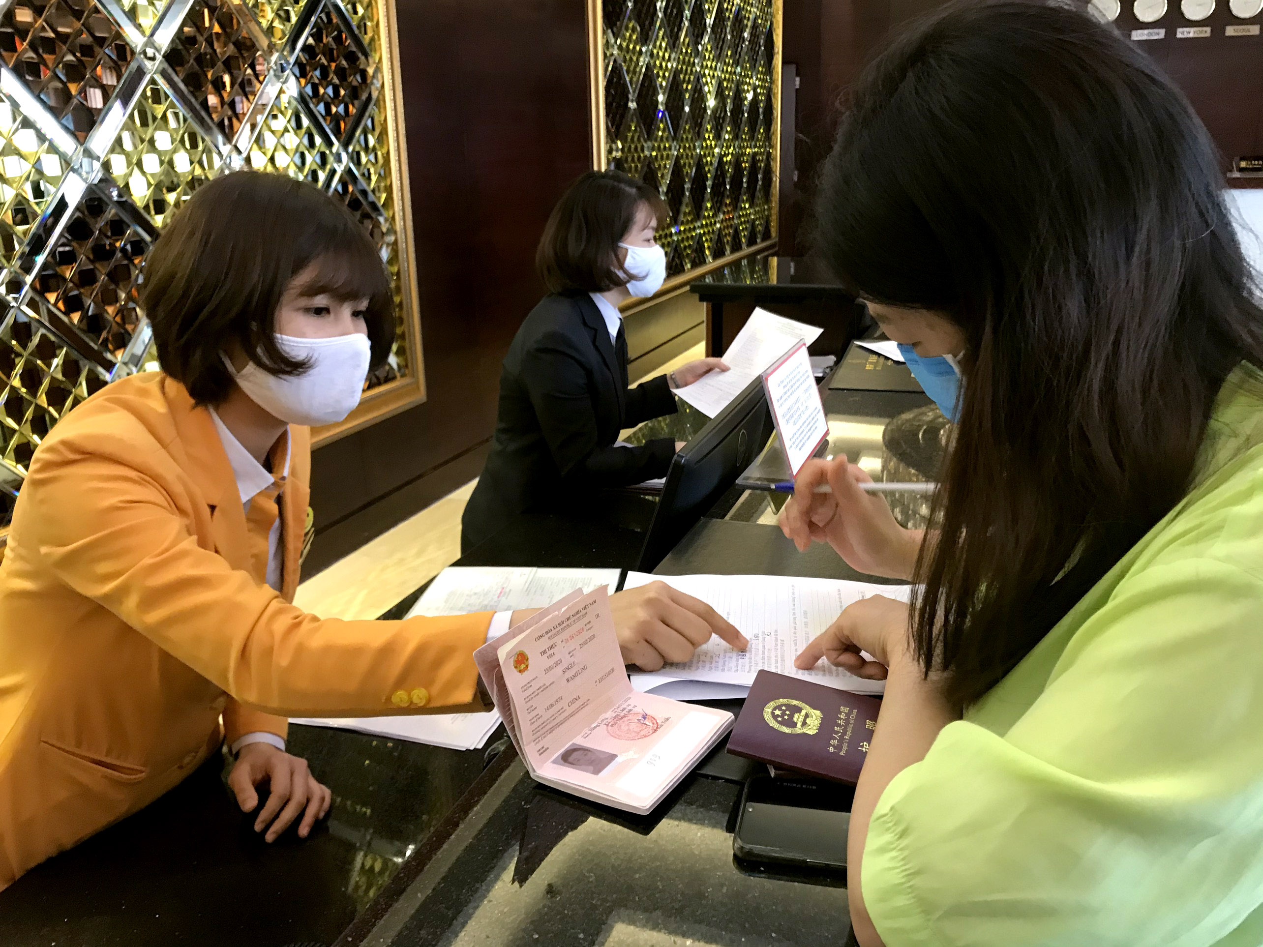 Nhân viên lễ tân khách sạn Hoàng gia Hạ Long hướng dẫn du khách khai báo y tế.