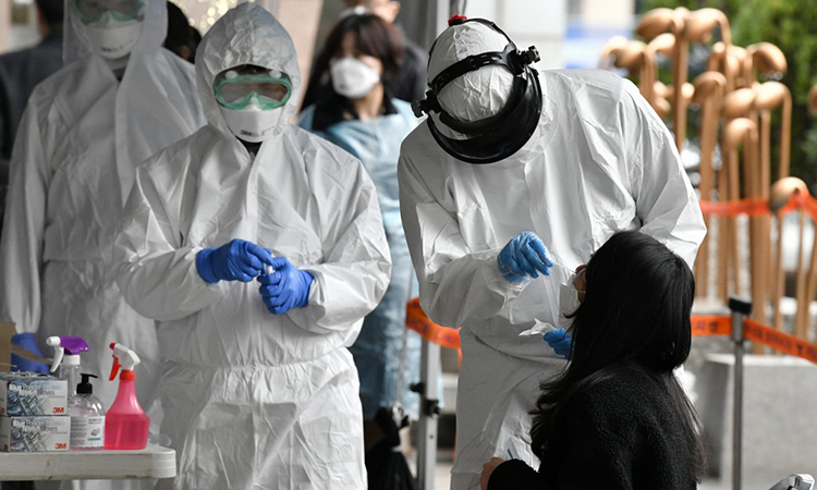 Nhân viên y tế Hàn Quốc ngày 10/3 lấy mấu xét nghiệm cho người lao động tại một tòa nhà ở Seoul, nơi phát hiện 46 ca nhiễm nCoV. Ảnh: AFP.
