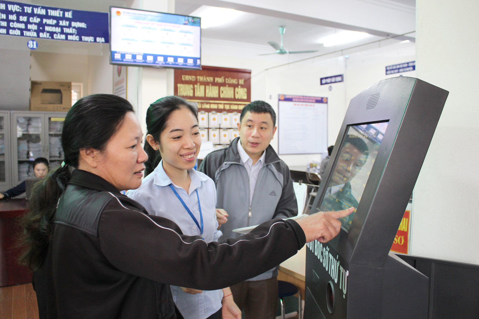 Cán bộ Trung tâm Phục vụ hành chính công TP Uông Bí hướng dẫn người dân lấy số thứ tự giải quyết TTHC.