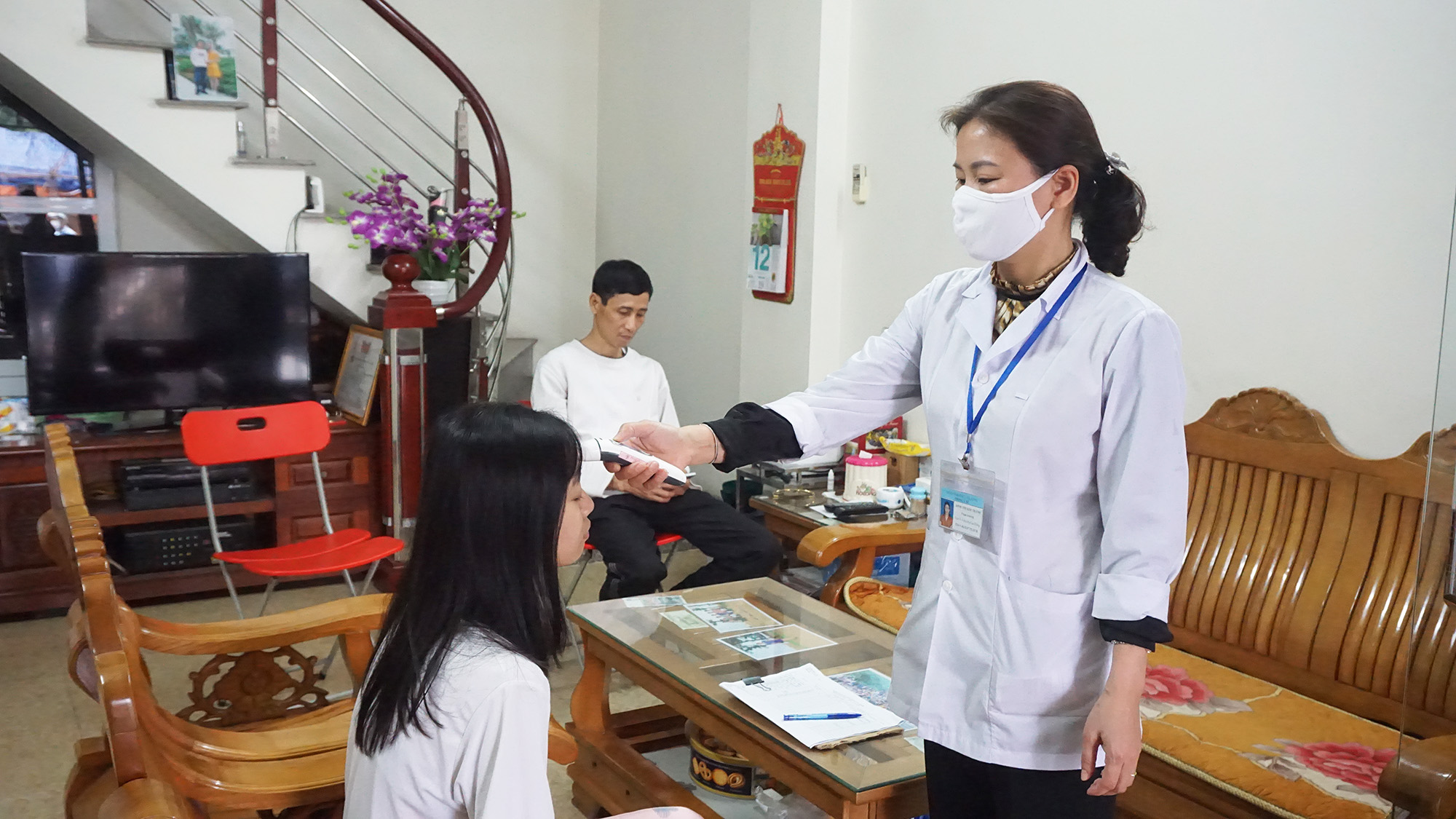 Cán bộ Y tế phường Cao Thắng (TP Hạ Long)  đo thân nhiệt, kiểm tra sức khỏe cho người dân