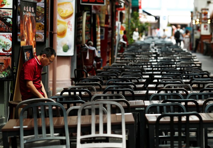 Châu Á cho đến nay là khu vực chịu ảnh hưởng nặng nề nhất vì vắng bóng du khách. Trong hình là cảnh nhân viên nhà hàng chờ khách trong khu phố người Hoa ở Singapore một ngày cuối tháng 2. Ảnh: Edgar Su/Reuters.