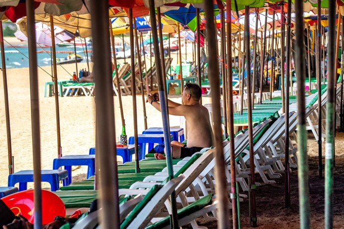 Du khách chụp ảnh giữa những hàng ghế phơi nắng gần như không người ở Pattaya, Thái Lan ngày 7/3. Ảnh: Mladen Antonov/AFP.