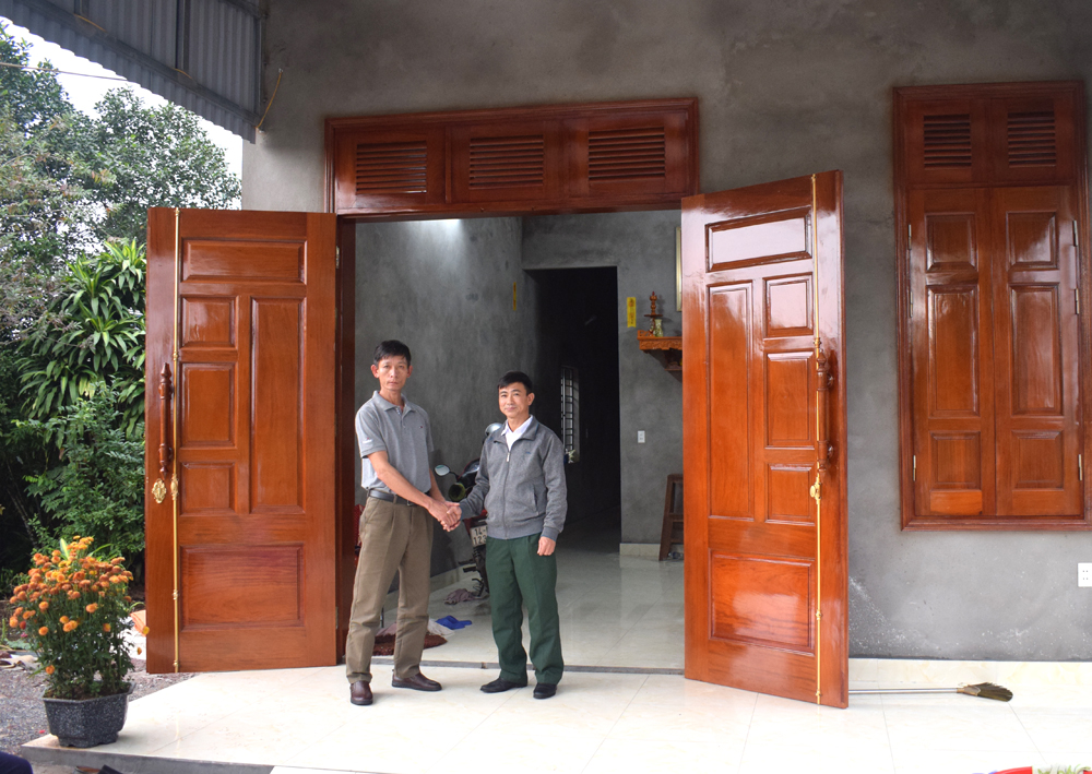 Nhừ sự giúp đỡ của ông Cường mà ông Phạm Văn Đông (bên trái) đã xây được nhà kiên cố và đã thoát nghèo