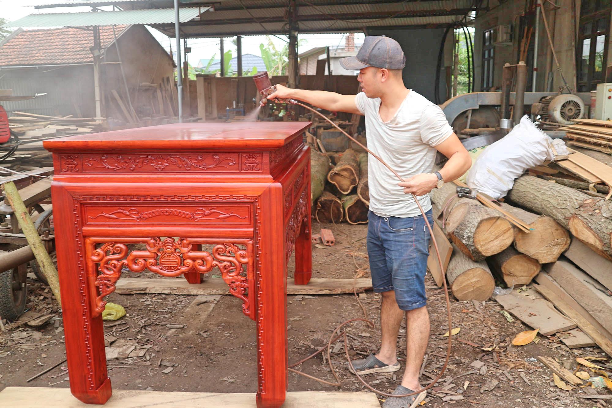 Anh Đinh Tuấn Vinh đang làm việc tại xưởng chế biến gỗ dân dụng của gia đình