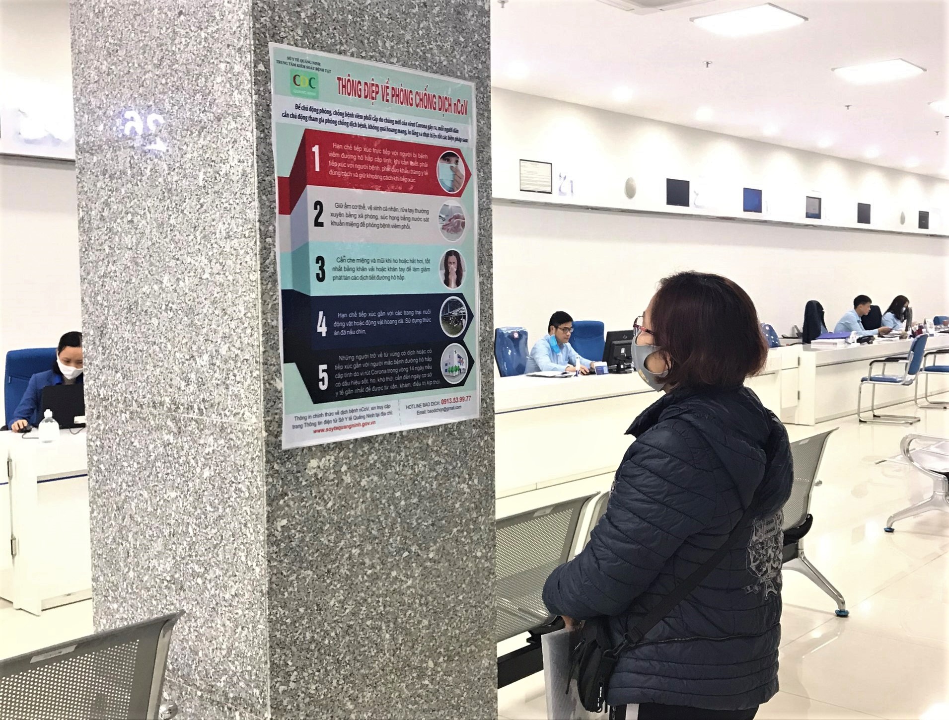 Người dân đọc các thông tin về phòng chống dịch bệnh Covid-19 tại Trung tâm Phục vụ hành chính công tỉnh. 