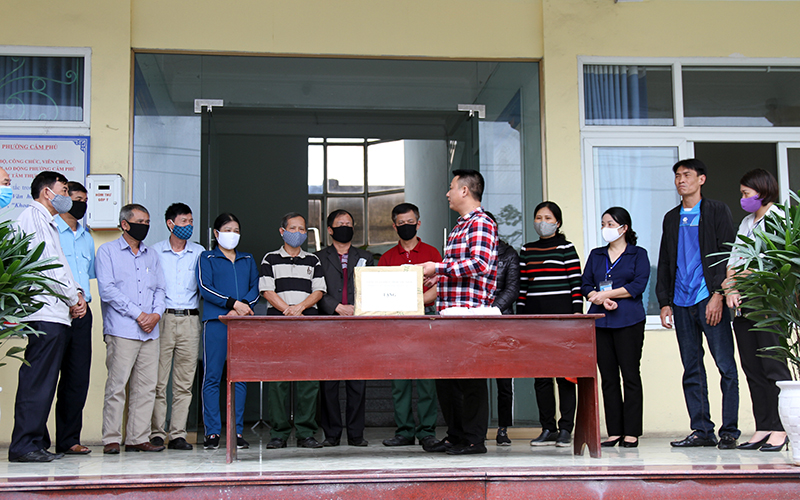 Lãnh đạo Công ty CP 198 Quảng Ninh trao tặng và hướng dẫn người dân phường Cẩm Phú sử dụng CloraminB để khử khuẩn.
