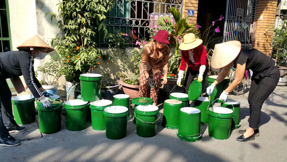 Chị em Hội LHPN phường Cẩm Sơn (Cẩm Phả) đang trang trí các thùng sơn thành các thùng rác thân thiện.