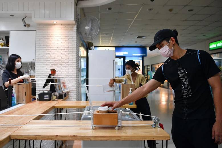 Nhà hàng cafe tại Bangkok, Thái Lan nghĩ ra sáng kiến hệ thống vận chuyển đồ uống cho khách nhằm hạn chế tiếp xúc gần. Ảnh: Reuters