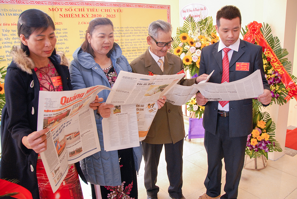 Các đại biểu dự Đại hội Đảng bộ xã Tân Bình, huyện Đầm Hà theo dõi thông tin tuyên truyền trên Báo Quảng Ninh.  