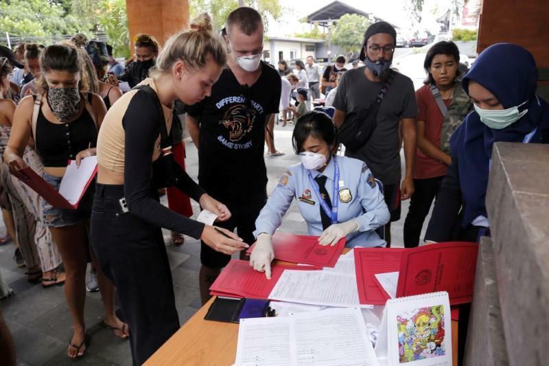 Cảnh sát xuất nhập cảnh hướng dẫn người nước ngoài thực hiện thủ tục xin gia hạn visa tại Bali ngày 23/3. Ảnh: Johannes P. Christo/Reuters.