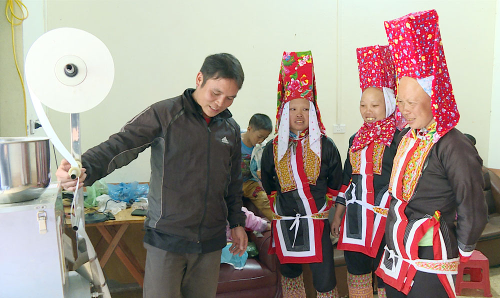 Anh Dường Cắm Hếnh hướng dẫn người dân thôn Khe Tiền, xã Đồng Văn, huyện Bình Liêu sử dụng máy đóng trà túi lọc. Ảnh: Nguyên Ngọc