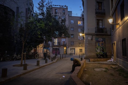 Anh Gana Gutierrez ngồi trên một con đường vắng ở Barcelona, Tây Ban Nha. Ảnh AP