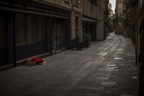 Một người vô gia cư dùng bìa carton làm chiếu ngủ. Ảnh AP