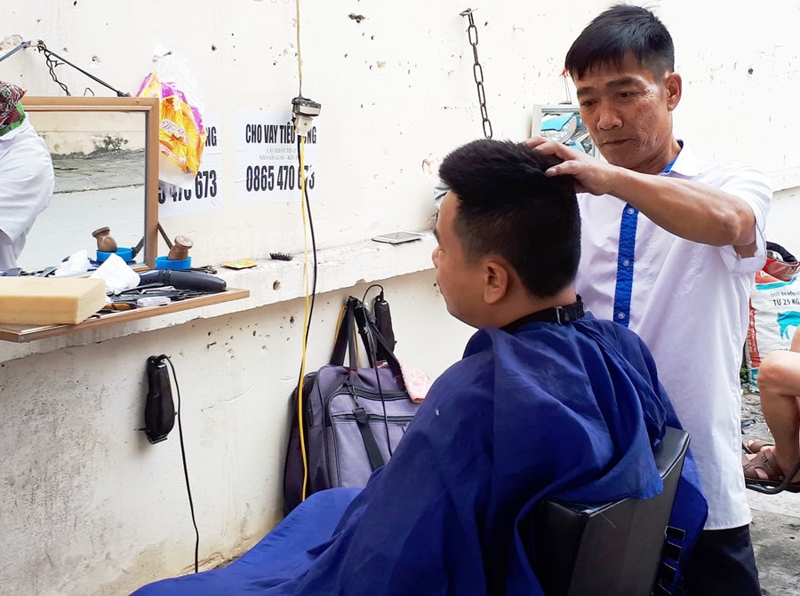 Ông Ngô Quang Đức làm nghề cắt tóc 20 năm qua không chỉ lo bản thân mà còn nuôi 2 con ăn học. 