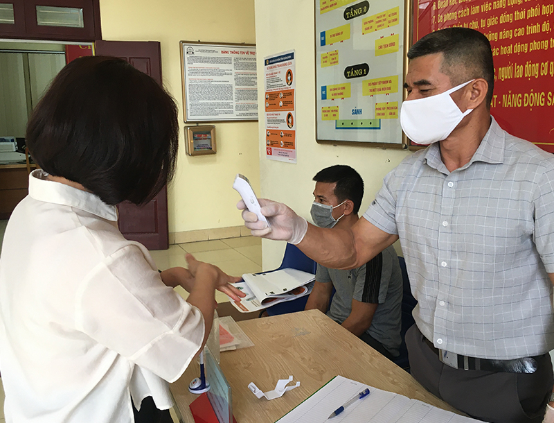 Phường Cẩm Thịnh bố trí nhân viên kiểm tra thân nhiệt của khách ra, vào trụ sở UBND phường.