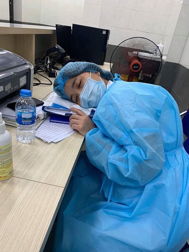  Nhân viên y tế ngủ gục bên bàn làm việc