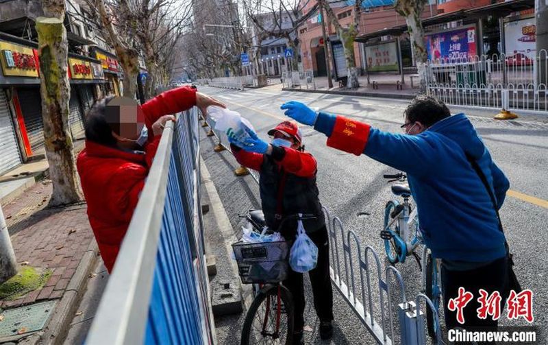 Tình nguyện viên đưa thuốc cho người dân trong khu vực bị quản lý khép kín tại Vũ Hán. Ảnh: Chinanews.