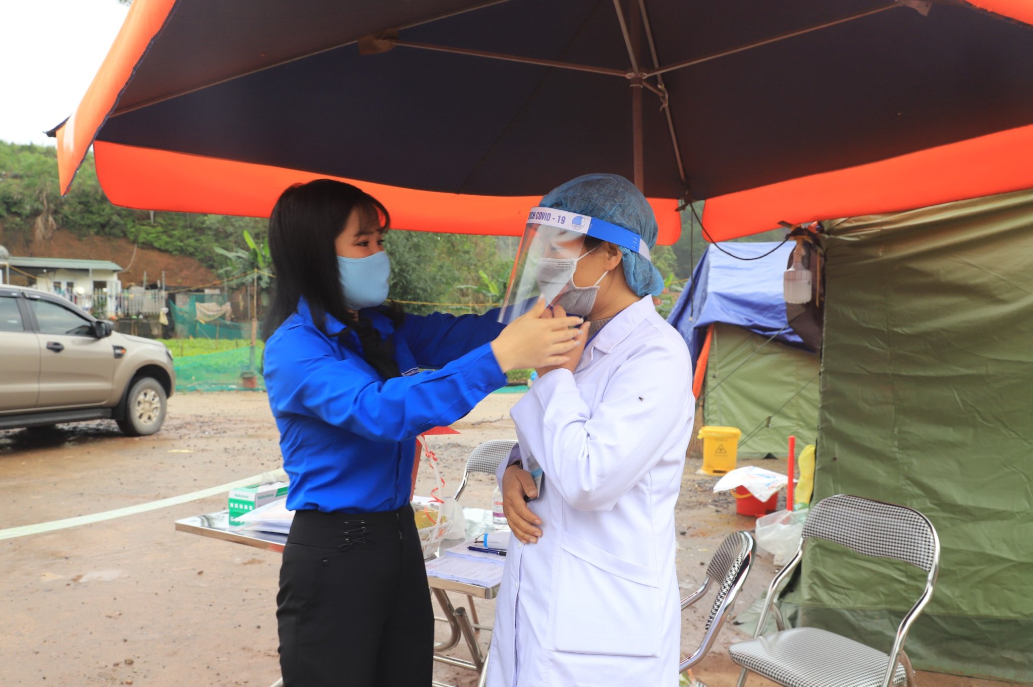 Huyện đoàn Bình Liêu hướng dẫn lực lượng y tế tại chốt kiểm soát cách đeo mặt nạ chống giọt bắn.