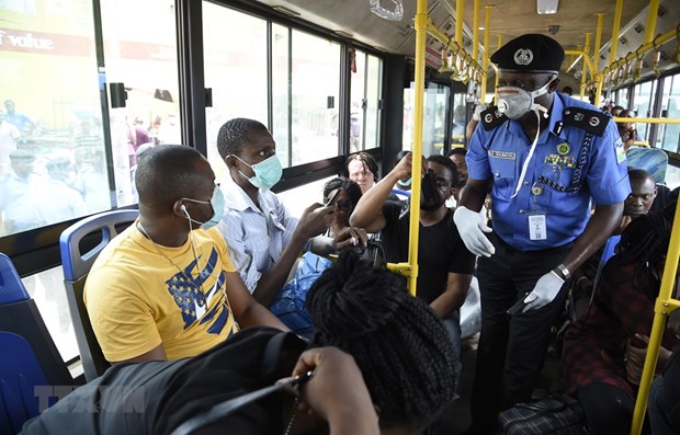 Cảnh sát nhắc nhở người dân các biện pháp phòng lây nhiễm COVID-19 tại Lagos, Nigeria. (Ảnh minh họa: AFP/TTXVN)