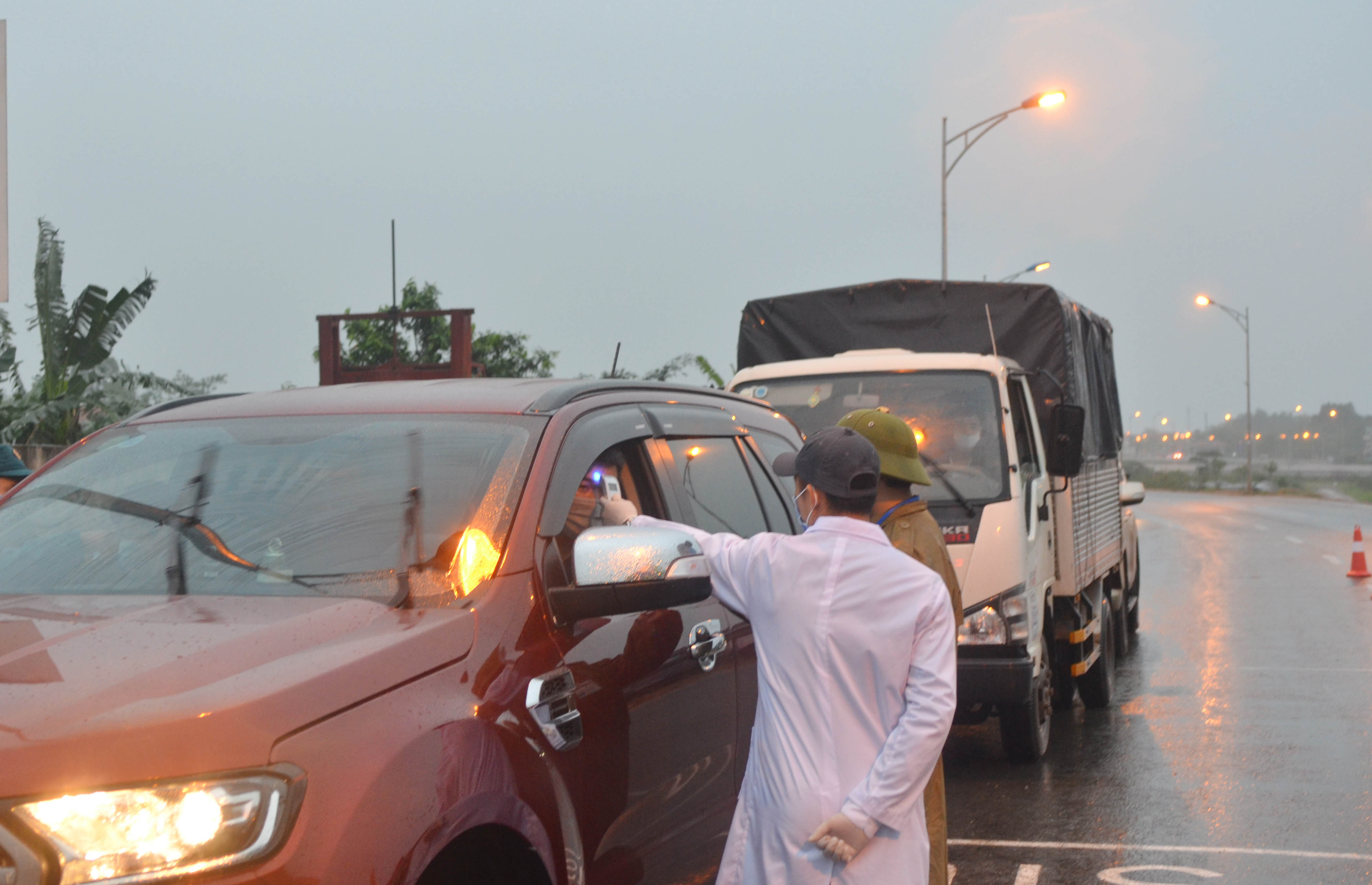 Cán bộ y tế kiểm tra thân nhiệt của người vào TX Quảng Yên tại chốt đường rẽ từ cao tốc Hạ Long - Hải Phòng xuống thị xã.