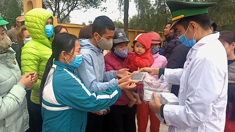 Cán bộ Đồn Biên phòng Trà Cổ phát khẩu trang y tế phòng dịch cho người dân trên địa bàn. Ảnh chụp ngày 25/3.