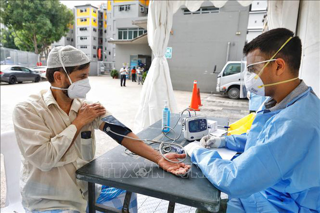 Nhân viên y tế lấy mẫu xét nghiệm COVID-19 tại khu nhà tập thể Toh Guan ở Singapore, ngày 8/4/2020. (Ảnh: THX/TTXVN)