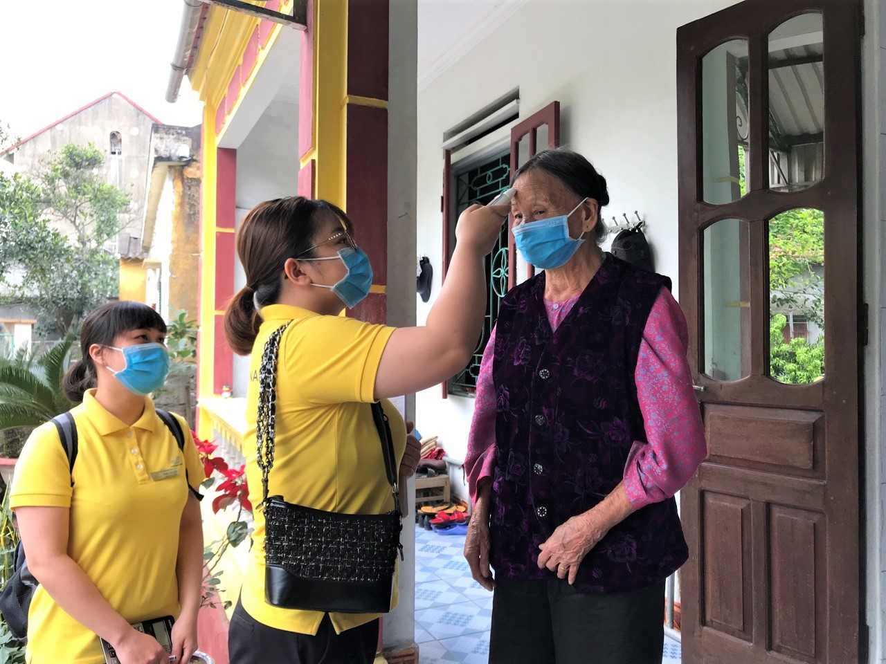 Nhân viên bưu điện TP Uông Bí đo thân nhiệt trước khi phát lương hưu tại nhà cho người dân. 