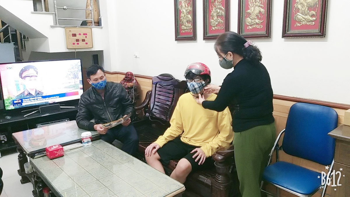 Cô Nguyễn Thị Thanh Tươi đang hướng dẫn người dân cách đội mũ bảo hiểm đúng cách để đảm bảo ATGT