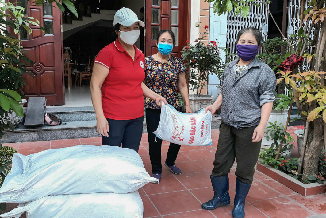 Các thành viên hội Chữ thập đỏ phường Hà Tu (TP Hạ Long) trao nhu yếu phẩm cho người nghèo.