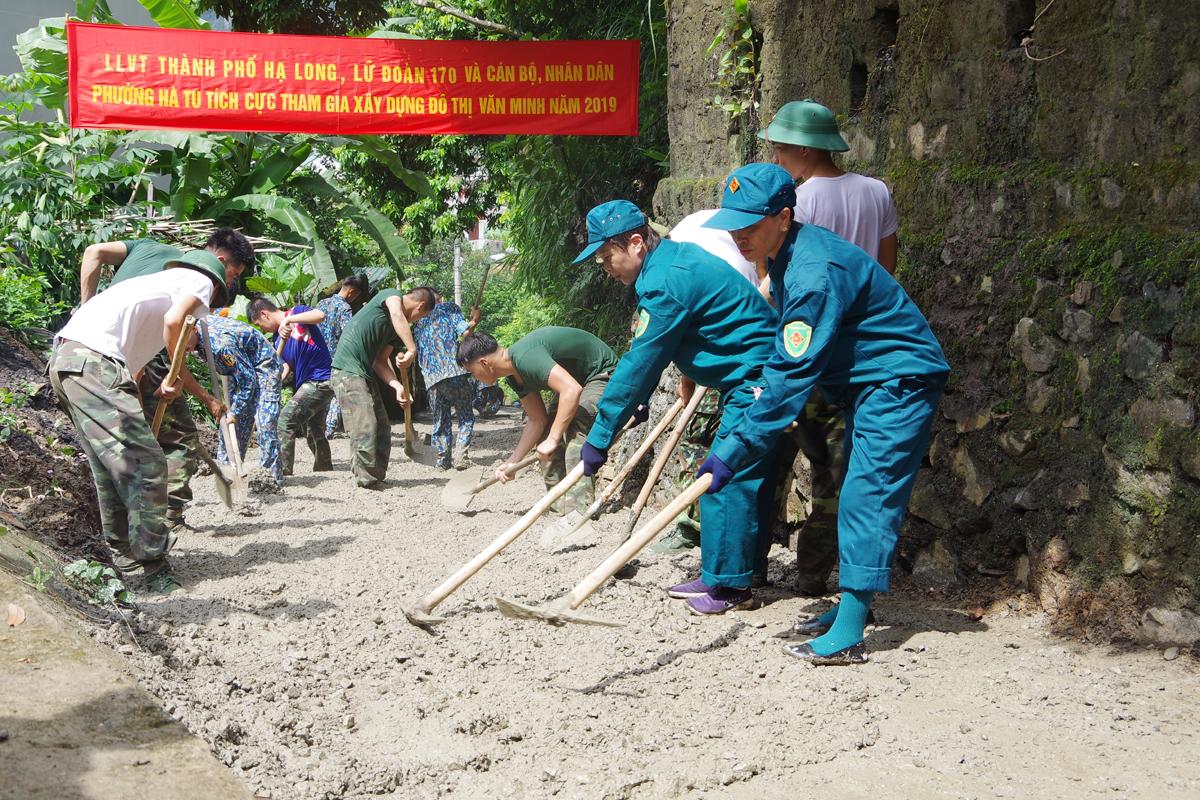 Các chiến sỹ DQTV TP Hạ Long giúp nhân dân phường Hà Tu làm đường bê tông.