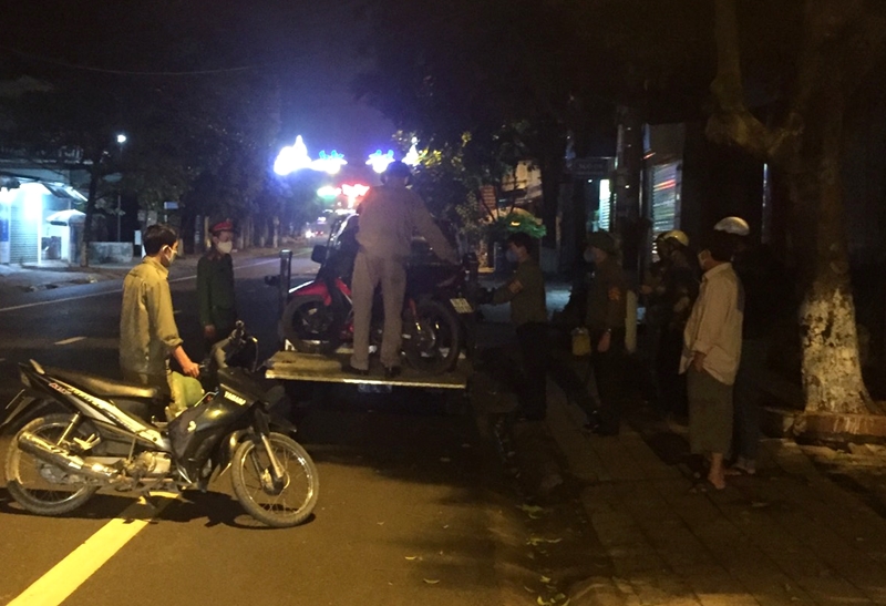 Lực lượng chức năng của phường Quảng Yên xử lý người và phương tiện ra đường sau 21h30. Ảnh chụp đêm 16/4.