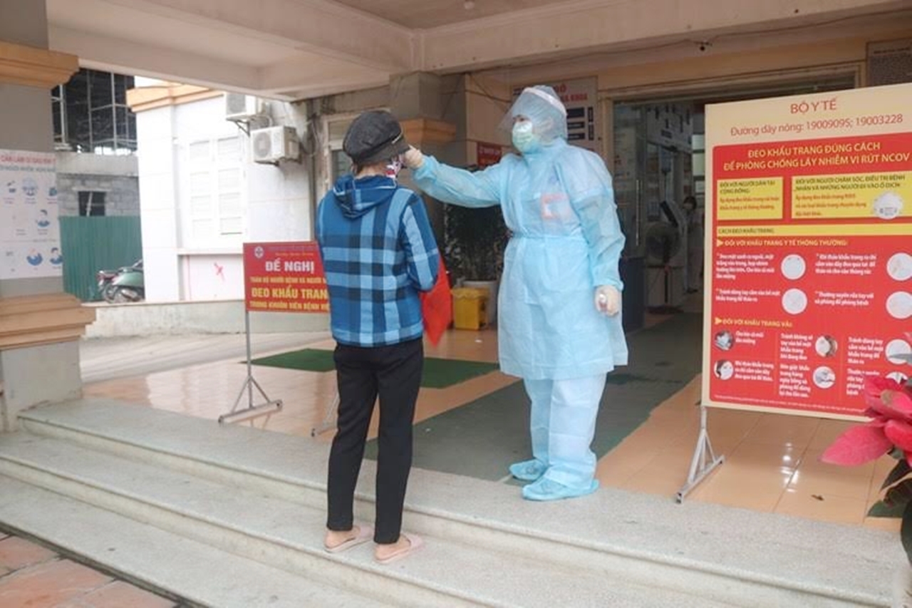 Người dân đến khám bệnh được đo thân nhiệt tại TTYT huyện Tiên Yên