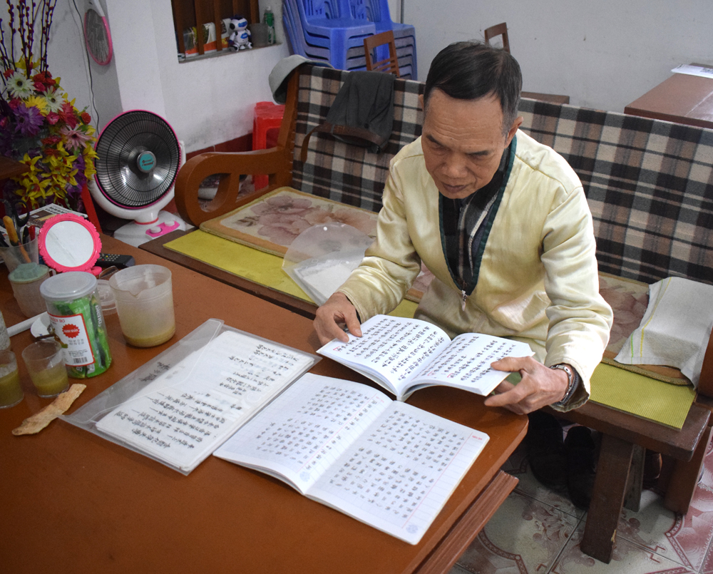 Ông Hà Xuân Tiến bên bộ sách mà mình đã biên soạn (ảnh chụp tháng 2/2020).